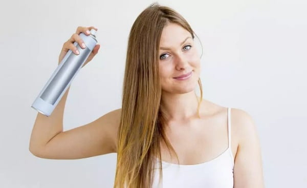 Woman-Sprays-Dry-Shampoo-Into-Her-Hair