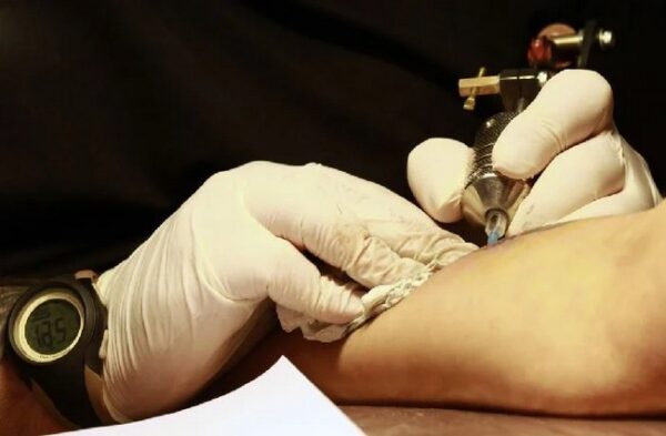 Hand Of A Tattoo Artist Making A Tattoo With His Instrument