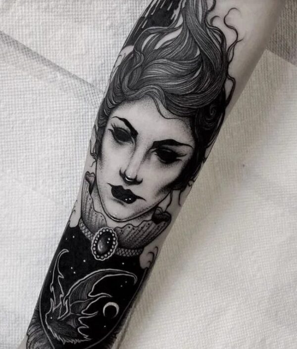 Large Black Face Shaped Woman'S Forearm Tattoo