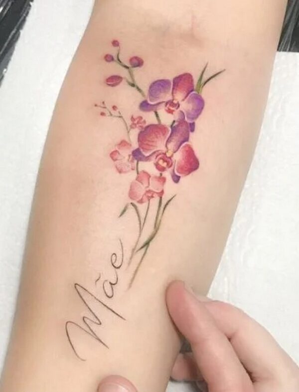 Woman'S First Name And Flower Colored Forearm Tattoo