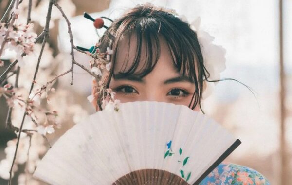 A Woman Behind A Fan With A Curtain Fringe