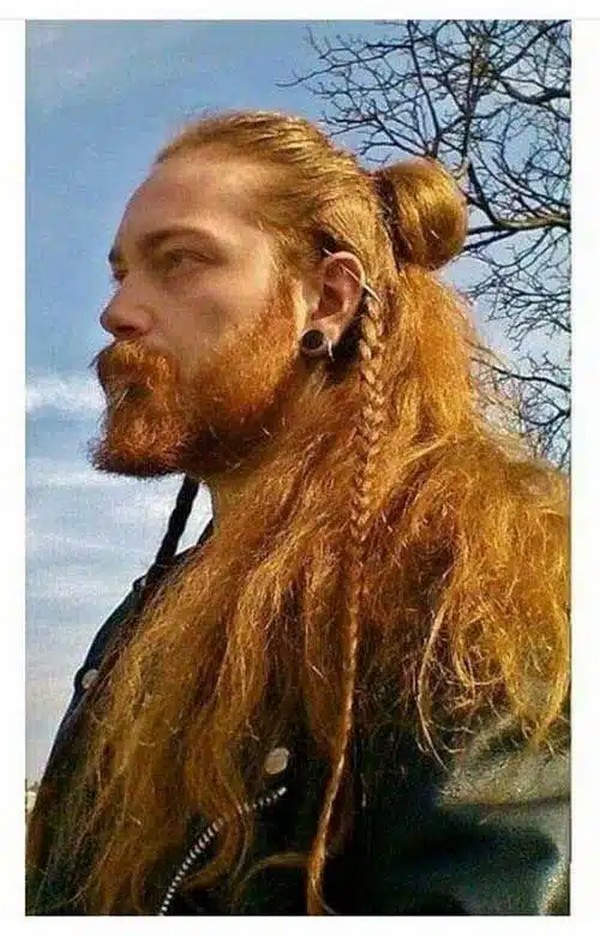 A Man With A Viking Haircut Including A Beard, Long Hair, Bun, Braids